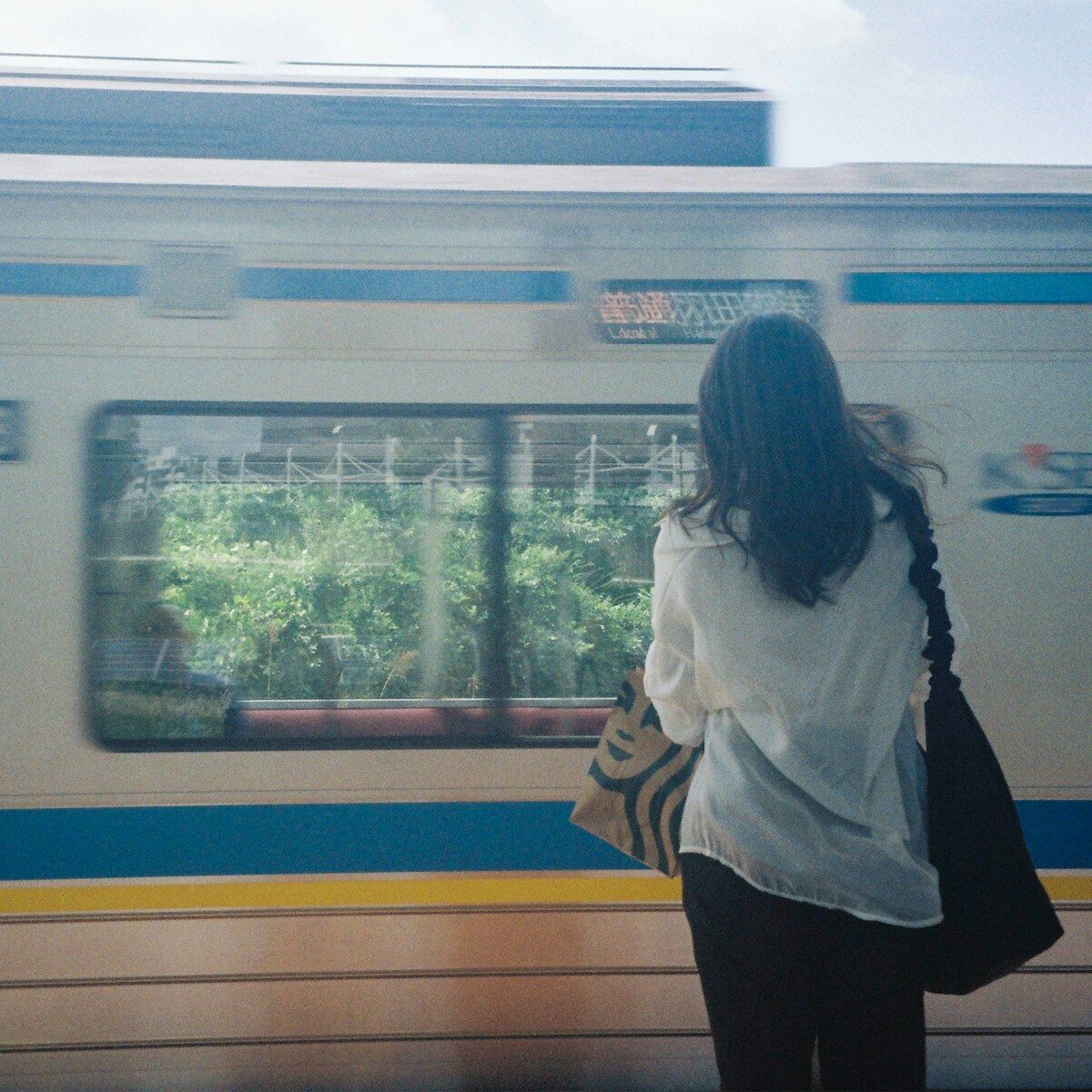 a woman waiting for a train at a train station