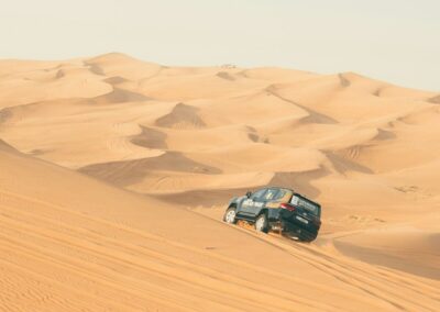 a car driving through the sand dunes in the desert