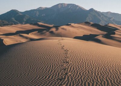 footprints on desert towards mountain